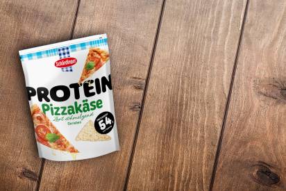 Der Schärdinger Protein Pizzakäse im Standbeutel auf einem Holzuntergrund